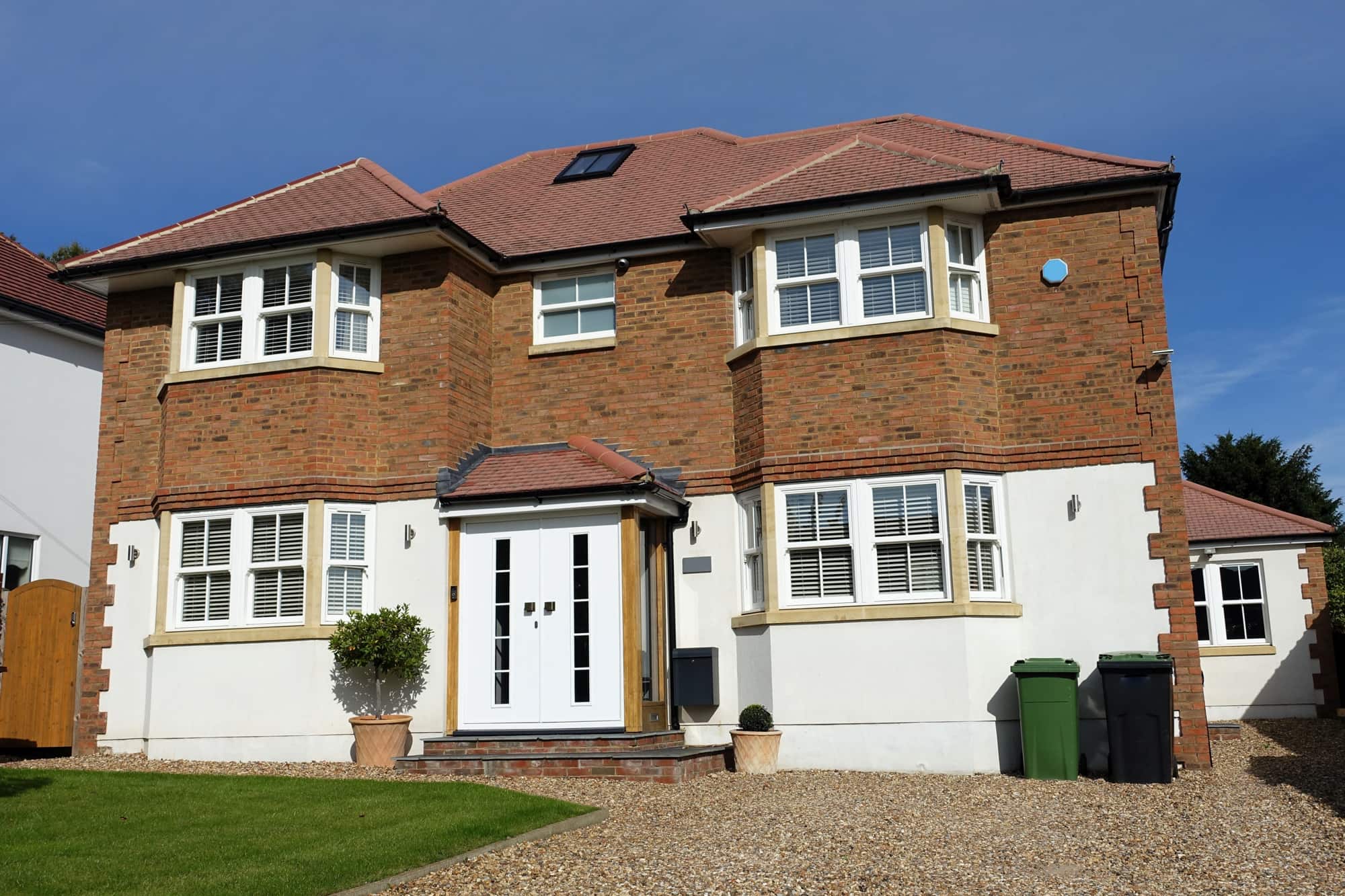 Detached Family House Driveway Detached brick and white-rendered house with bay windows and a gravel driveway.